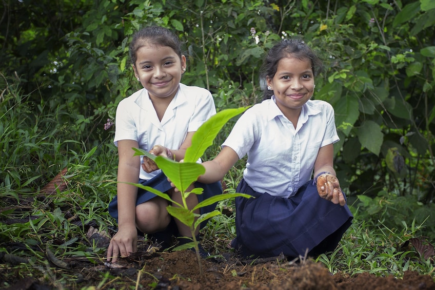 Young girls with a young tree in Costa Rica