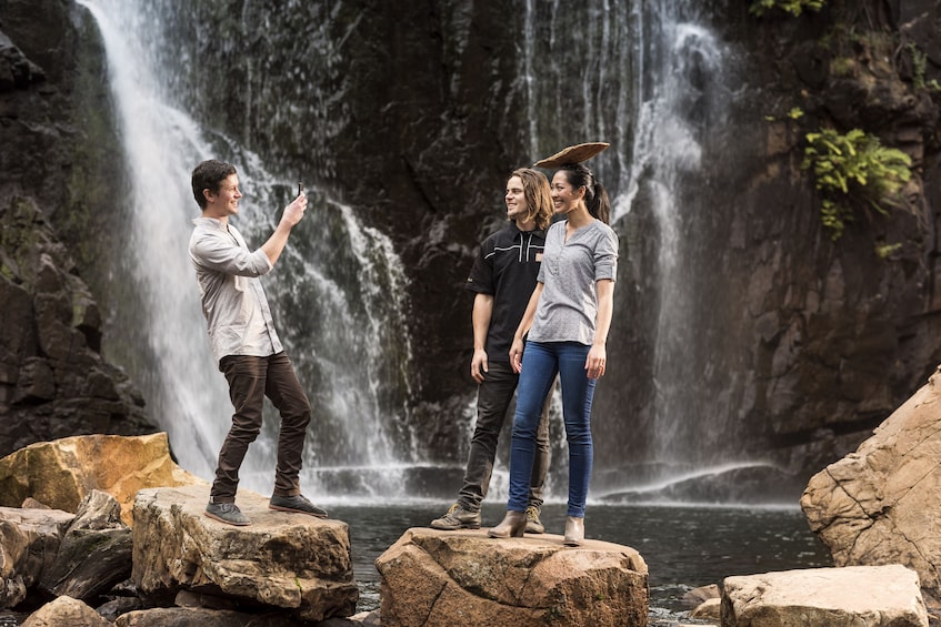 Show item 3 of 10. Couple taking a photo by a waterfall in Australia