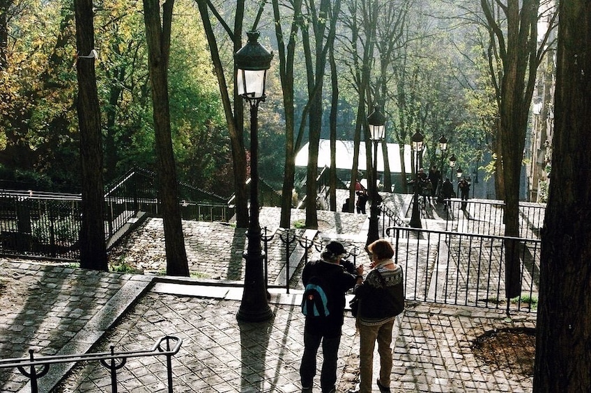 Two people walking down park steps in Paris