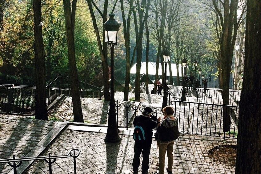 Two people walking down park steps in Paris