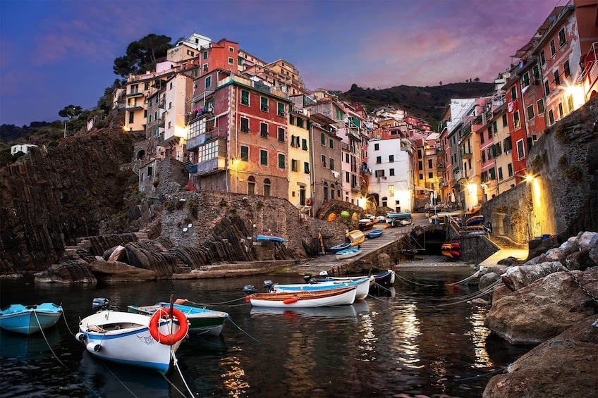 Show item 2 of 5. Boats on a harbor in Cinque Terra at dusk