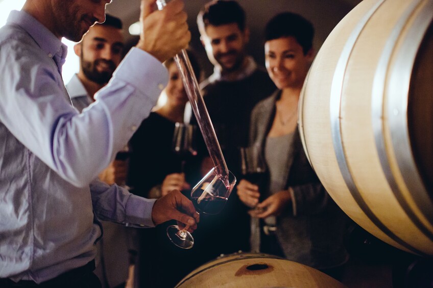 Tasting wine out of a barrel at a winery
