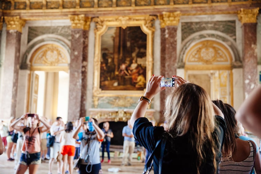 People take pictures inside Versailles chateau