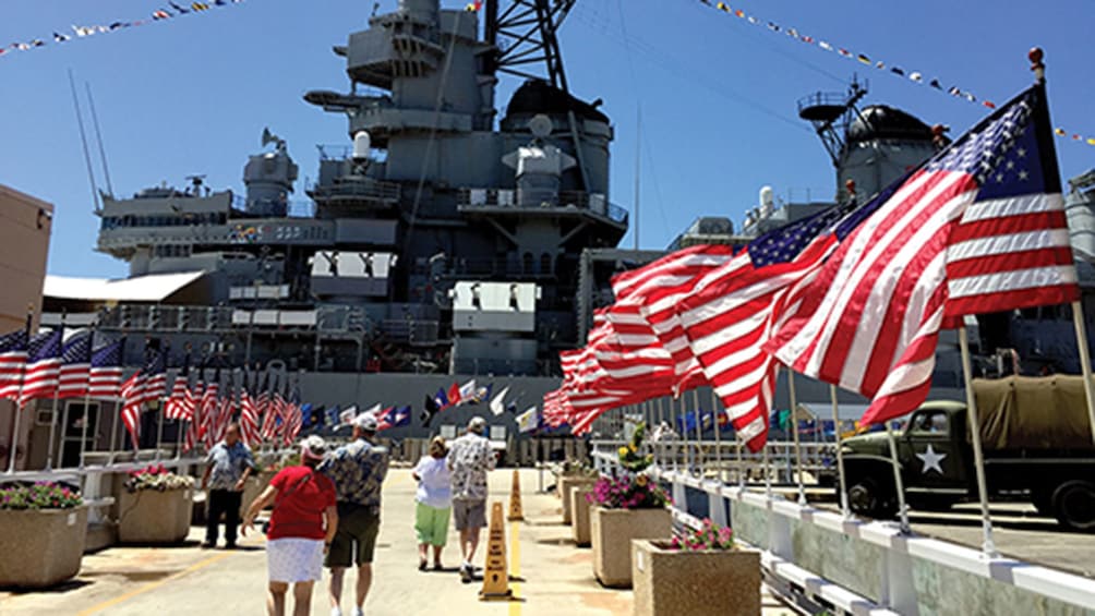 US flags wave at the entrance to USS Missouri