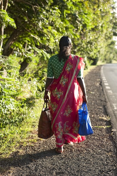 Woman walking alongside a road in Mauritius