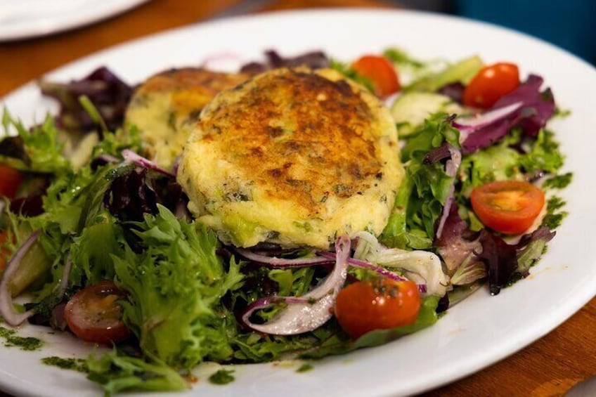 Pictured here is our vegan option which is a modern twist on a traditional Irish dish, "colcannon" cakes served on a bed of seasonal salad from our kitchen garden.