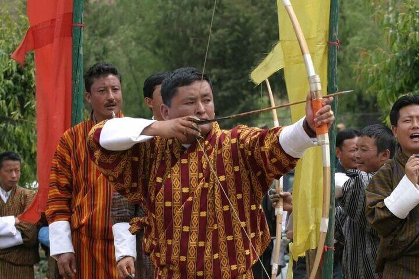An archer is traditional dress taking aim