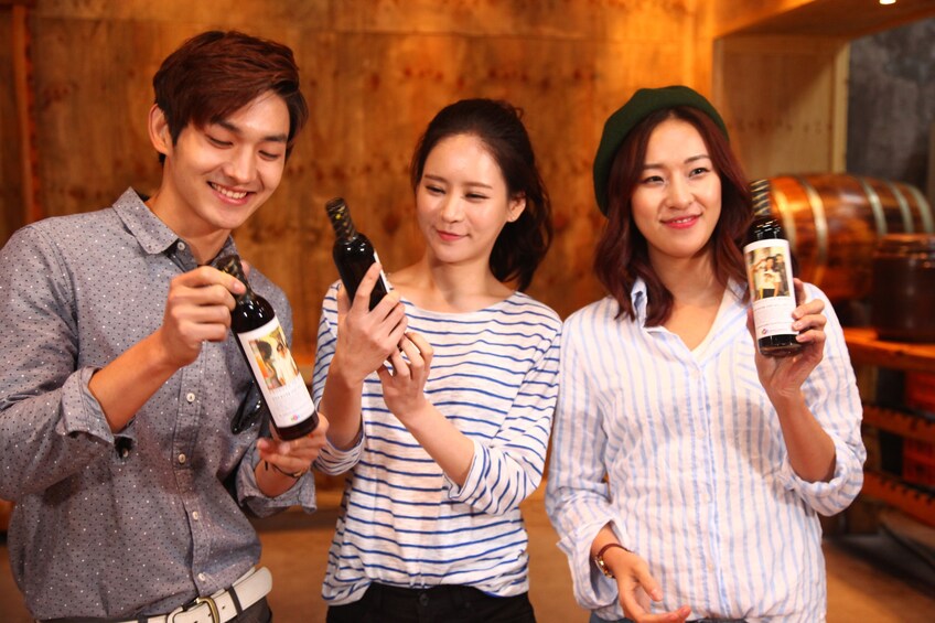 正在顯示第 4 張相片,共 10 張。 Three friends hold up bottles of beer in South Korea