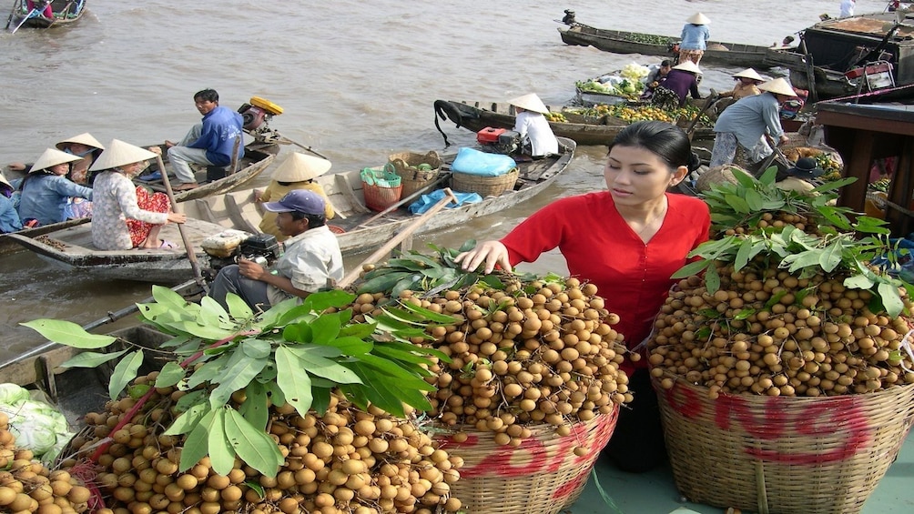 Woman selling longan at Cai Be floating market 