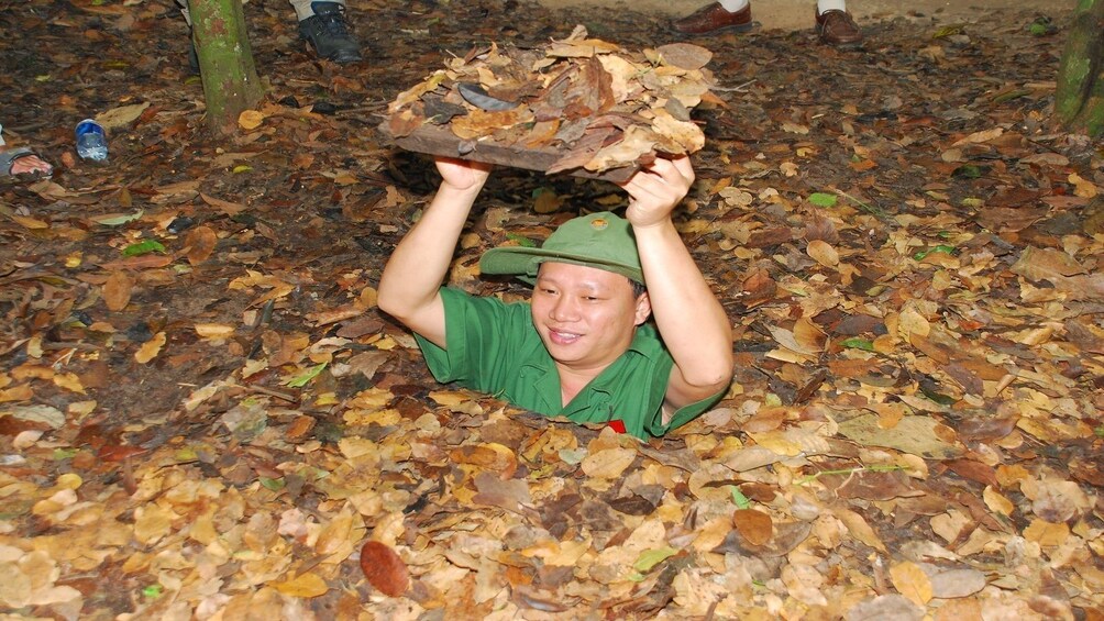 Tour guide going through the Cu Chi Tunnels 