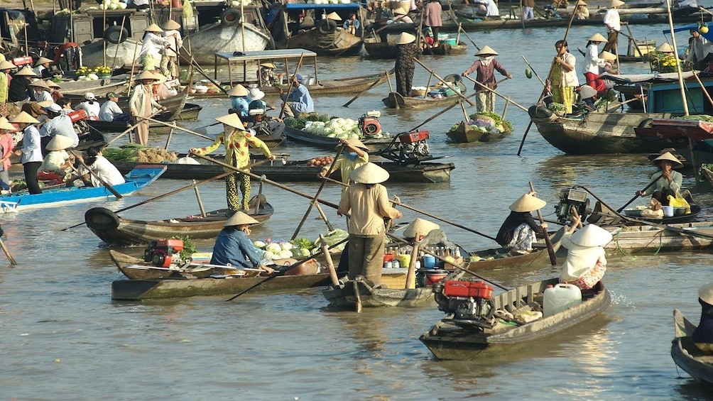 Locals carrying goods via wooden boats along the Mekong Delta 