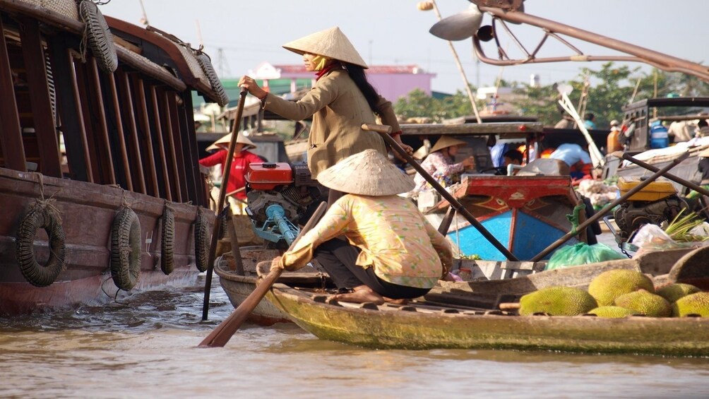 Locals floating down the Mekong Delta by boat transporting goods 