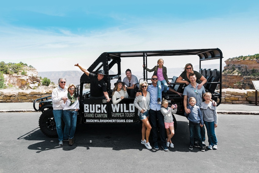 Group posing for a photo with a Hummer while on the Grand Canyon tour 