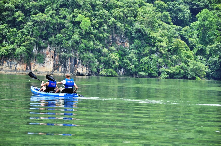 Two tourists row kayak on Ba Be Lake in Vietnam