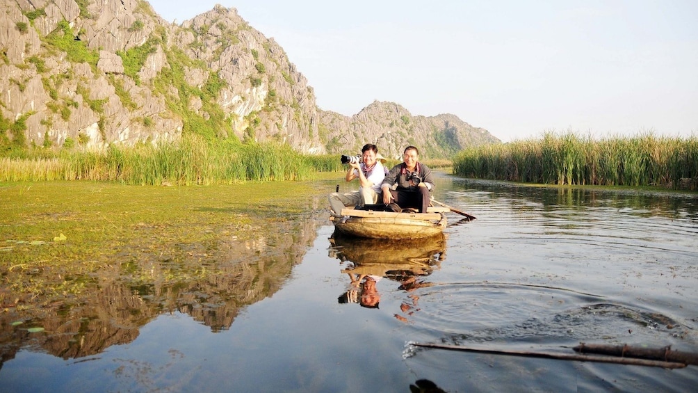Men on a boat to Thung Nham bird park