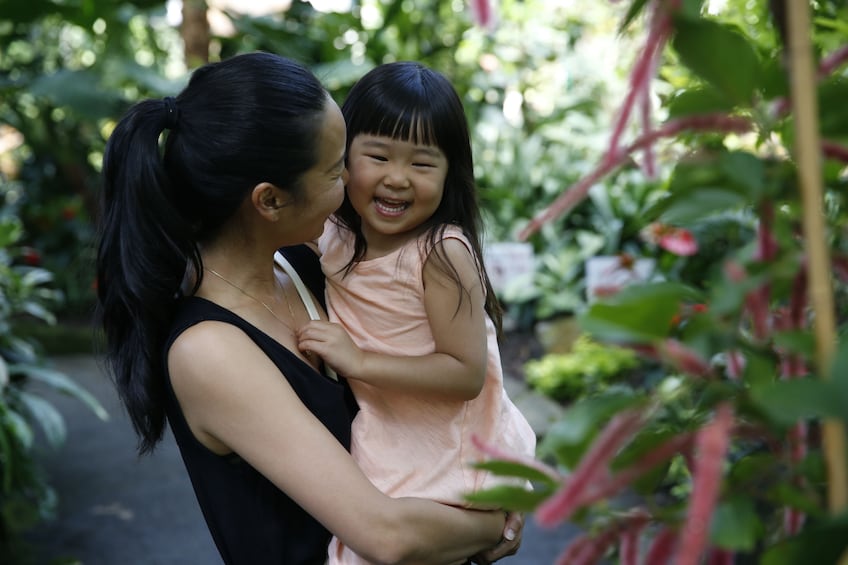 Mom carrying child at the Bloedel Conservatory in Vancouver, BC, Canada