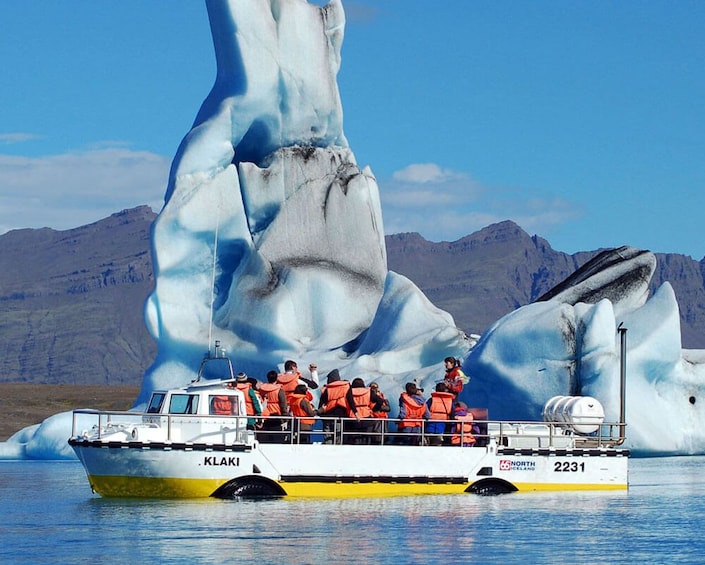 Boating group next to large glacier in the water in Iceland