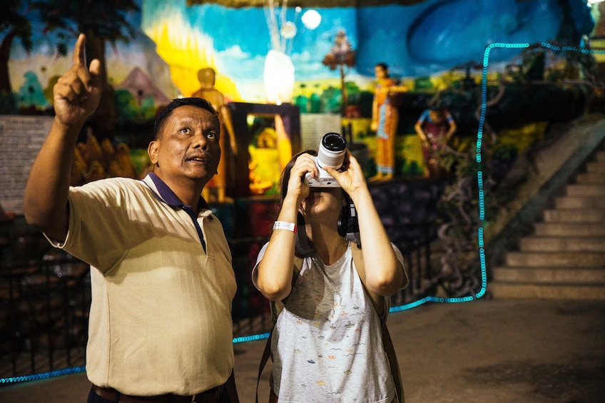 Show item 5 of 10. Tourists taking photos inside Batu Caves in Kuala Lumpur