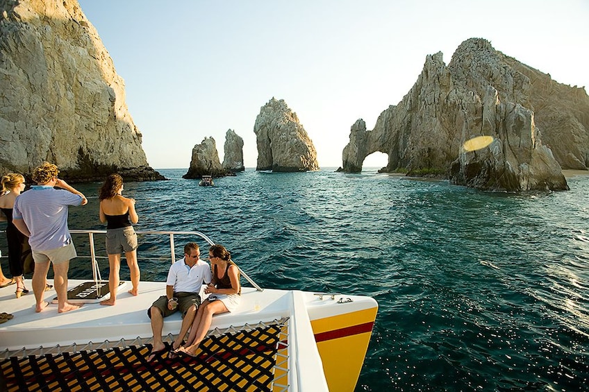 Guests enjoying the views of Arch of Cabo San Lucas from a catamaran 