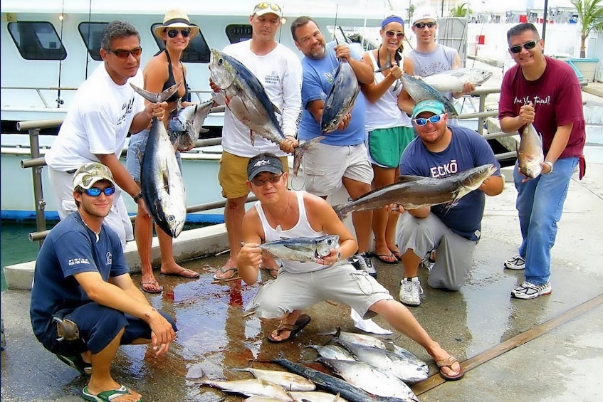 Group holding their catch on a sports fishing tour in Biscayne Bay, Miami