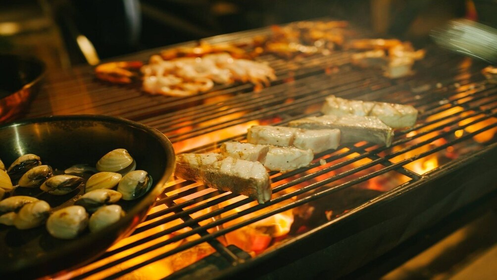 Clams, fish and shrimp cooking on a barbeque
