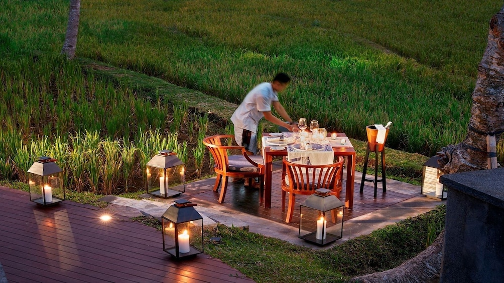 Man sets outdoor table for dinner in Nha Trang's Rice Paddy Fields