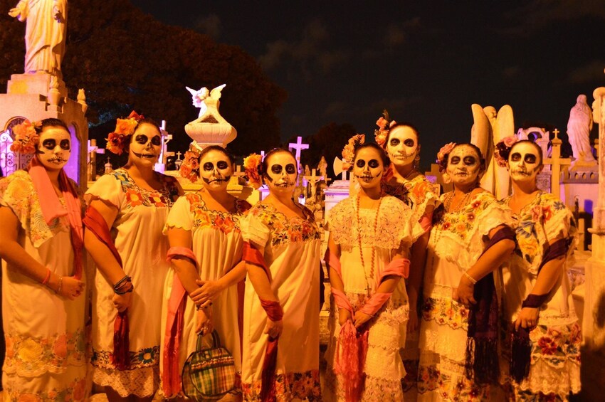 Women in Day of Dead skeleton face paint at a cemetery in Mexico