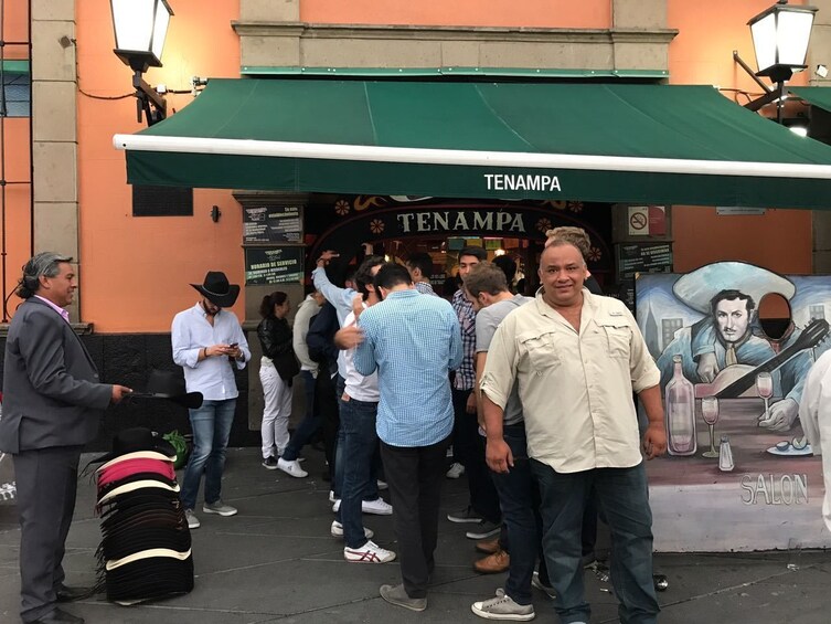 Man standing in front of Tenampa bar and grill in Mexico City 