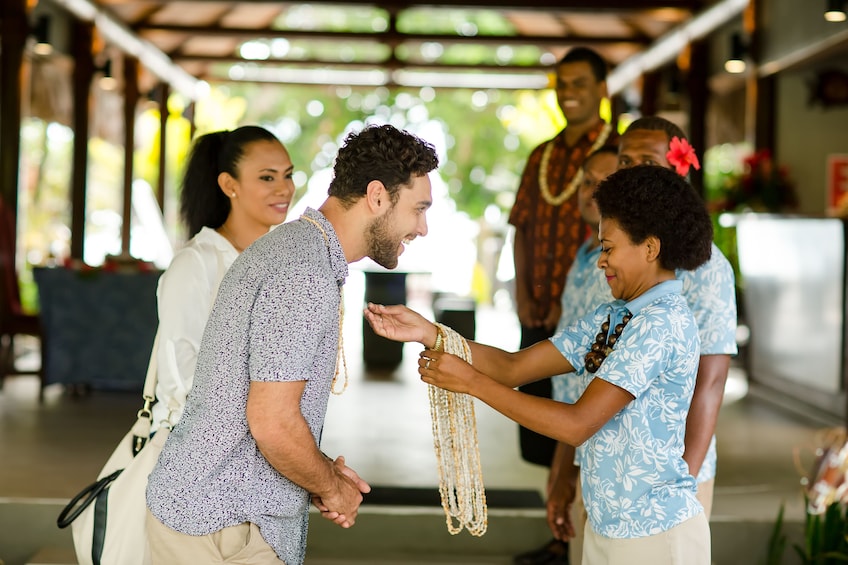 Man being adorned with a beaded necklace in Fiji