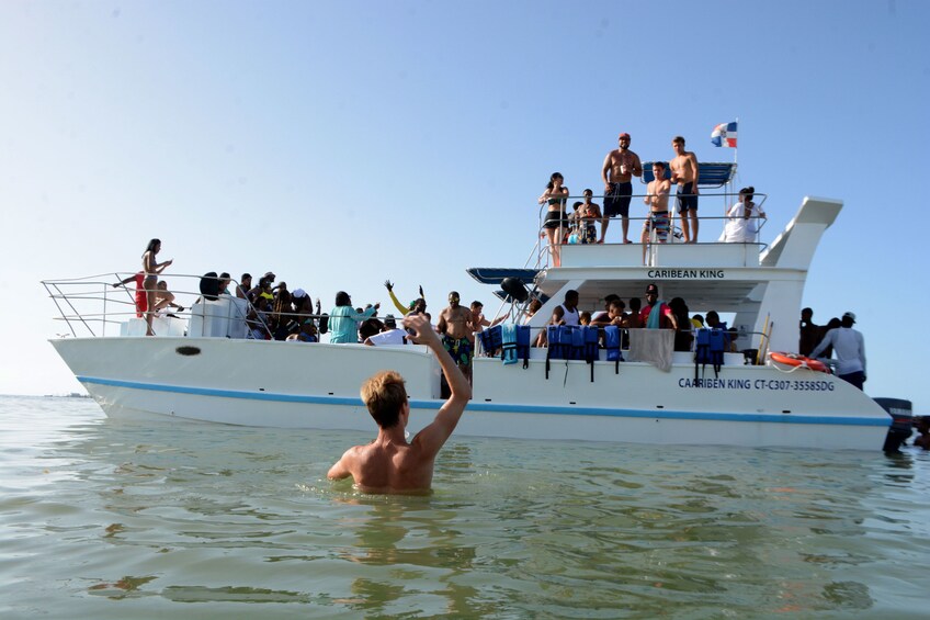 Man in the water next to a party boat in the Caribbean