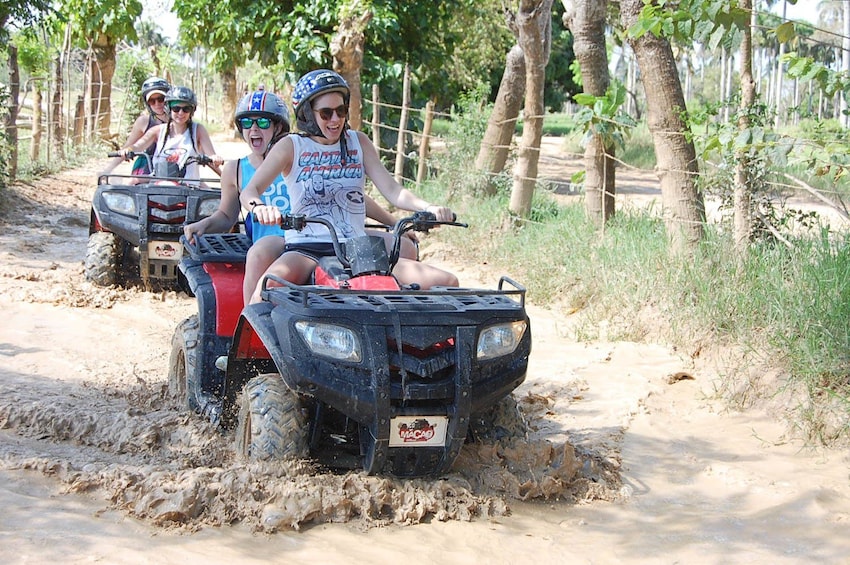 People driving ATVs through the mud in Punta Cana