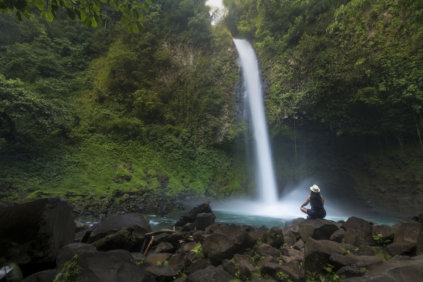 Woman sitting by a waterfall in Costa Rica