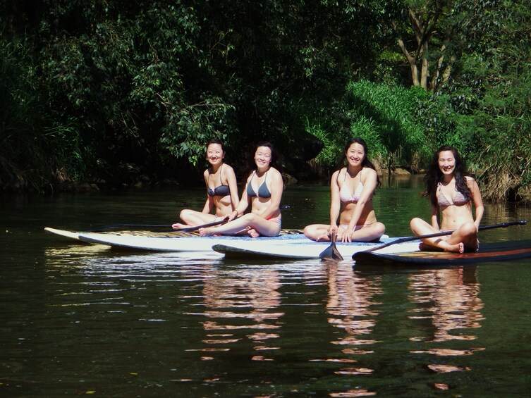 Group of women sitting on paddle boards at Haleiwa Beach Park 