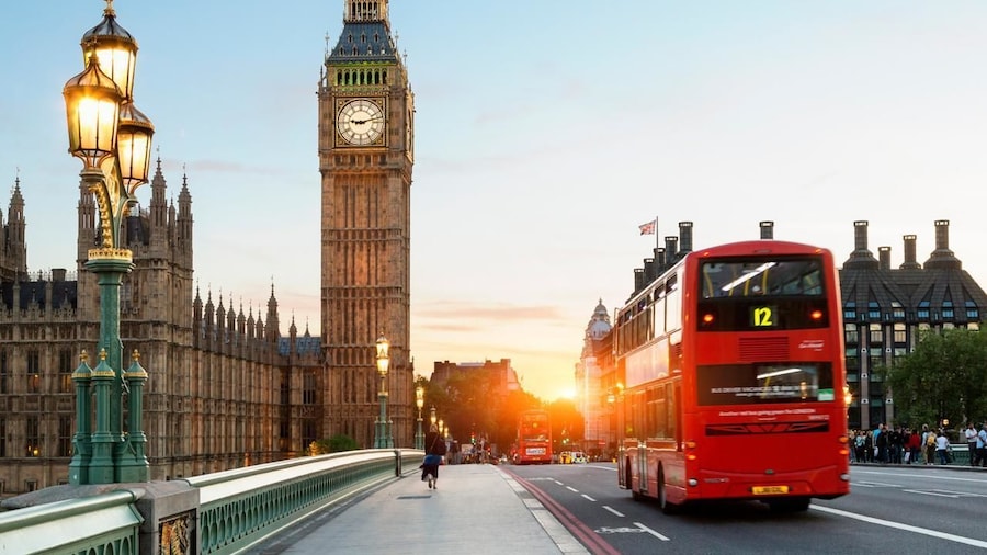 Red double-decker bus on the streets of London in the evening