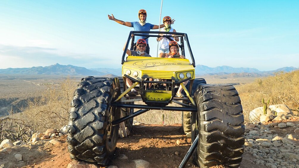 People pose with off roading vehicles on a Desert trail