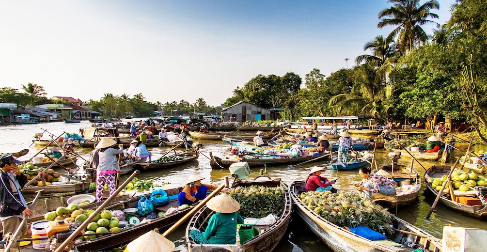 Produce being sold on wooden boats along the Mekong Delta during the day in Vietnam