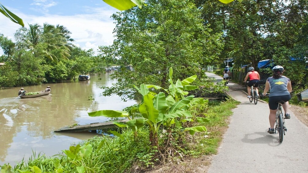 Bicycling group on a riverside path in Vietnam