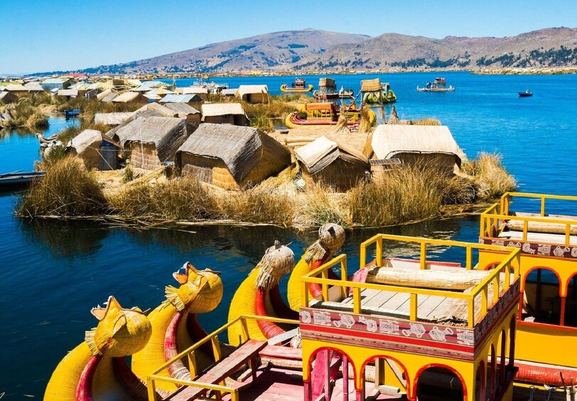 Large colorful boats and small homes on the Uros people on Lake Titicaca in Peru
