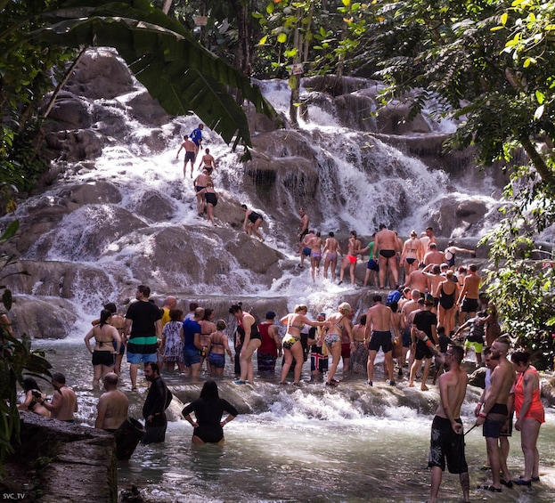 Tourists climb Dunn's River Falls in Nine Miles, Jamaica
