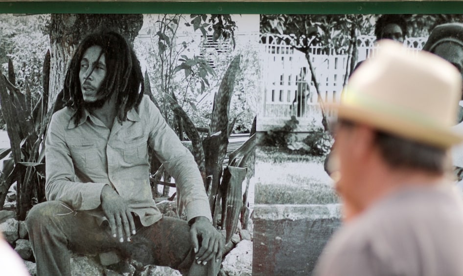 Tourist looking at black and white photo of Bob Marley