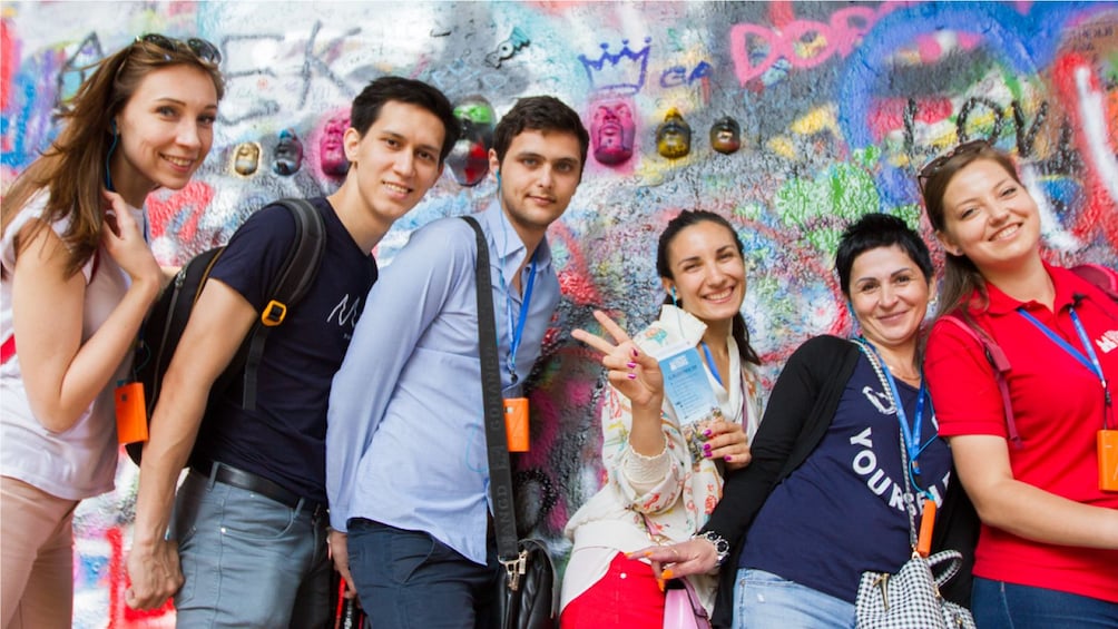 Show item 1 of 9. Tour group in front of graffiti mural in Prague