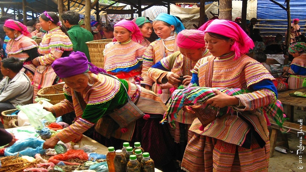 Women in traditional dress work at the market in Vietnam