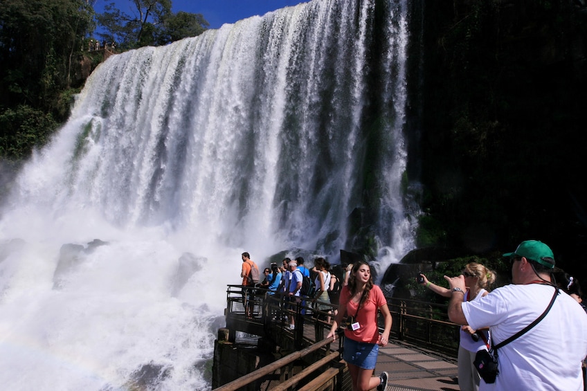Woman poses for picture in front of Iguazu Falls in Argentina