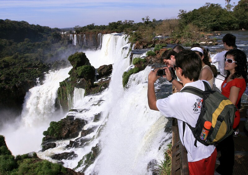 Tourists take photos from lookout over Iguazu Falls