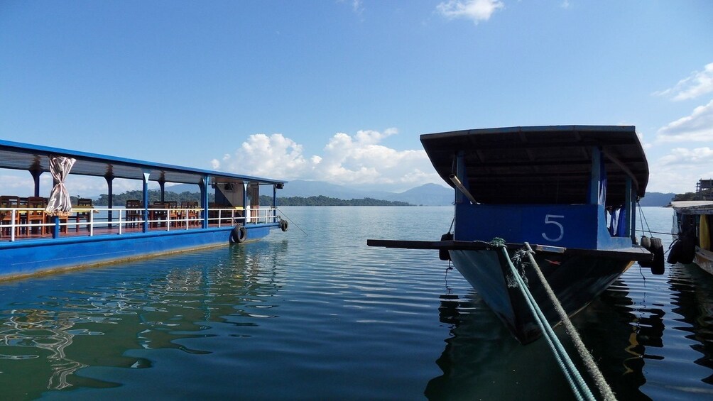 Blue boat docked on Mekong River in Laos on a sunny day