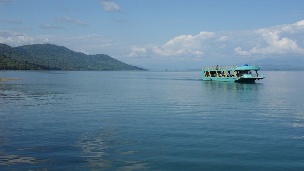 Bright teal boat on calm Mekong River in Laos
