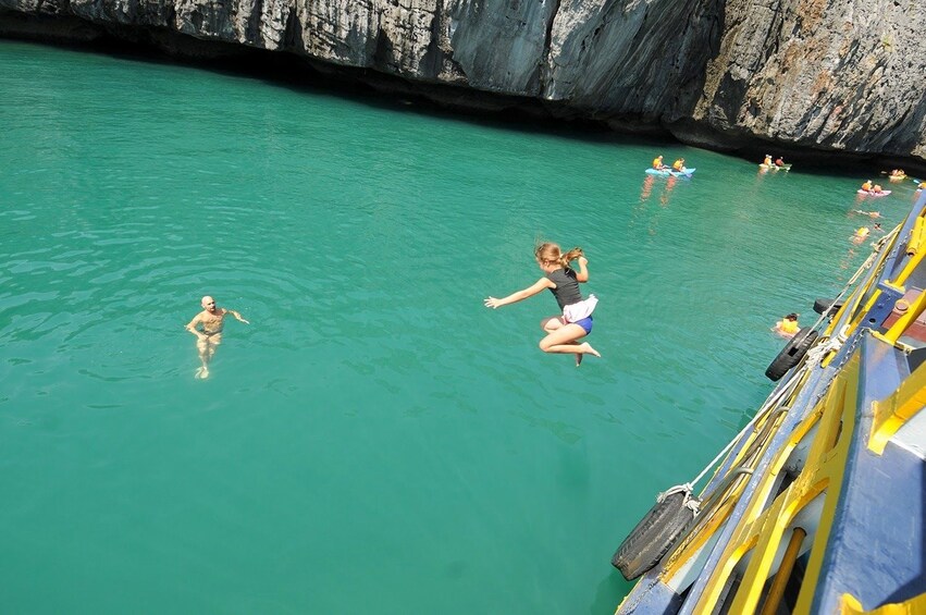 Girl jumping into the water for a swim at Angthong Marine Park 