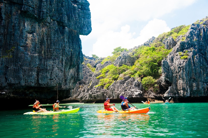 Group kayaking by the caves and tunnels of Angthong Marine Park 