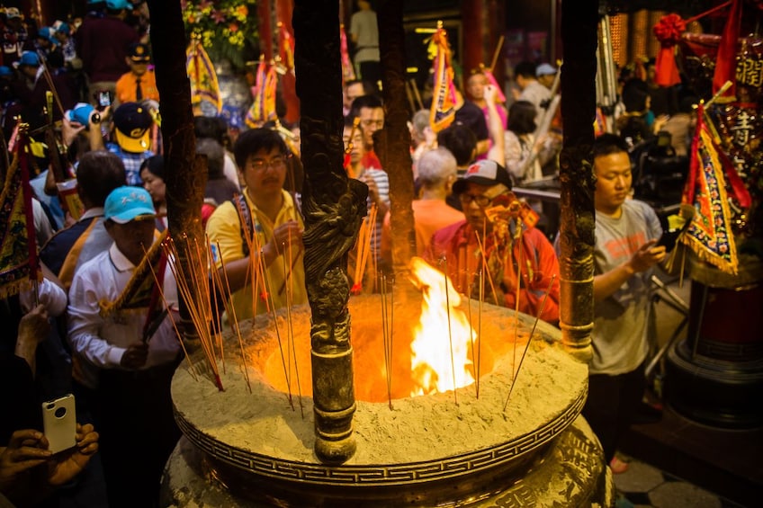 Show item 3 of 3. Visitors burning incense at a temple in Taiwan