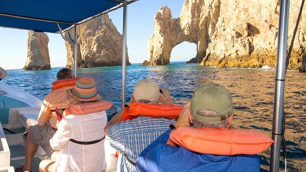 Tourists in boat take photos of the Arch of Cabo San Lucas